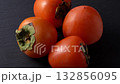Fresh persimmons ripe rotation on dark background 132856095