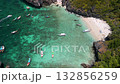 Aerial view of tropical bay with boats anchored near white sandy beach surrounded by turquoise water, cliffs, and lush greenery on Phi Phi Island in Thailand. Travel, vacation, and paradise themes. 132856259