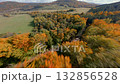 FPV drone flight over colorful autumn forest with green pine trees and orange foliage. Cinematic aerial view of fall mountains and scenic natural landscape. 132856528