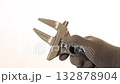 A gray gloved hand holding adjustable wrench on plain background showing metallic shine, grip texture, and tool function 132878904