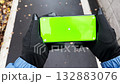 Handheld view of person walking outdoors holding smartphone with green screen 132883076