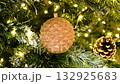 A painted Christmas tree decoration. It depicts a closed, golden pine cone, a symbol of wealth and success. It evokes a Christmas fairy tale and a cheerful mood. 132925683