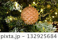 A painted Christmas tree decoration. It depicts a closed, golden pine cone, a symbol of wealth and success. It evokes a Christmas fairy tale and a cheerful mood. 132925684