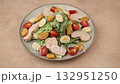 Caesar salad with chicken, cherry tomatoes, croutons, parmesan cheese, quail eggs and romaine lettuce. A woman adds cheese to a plate. Traditional American dish. Close-up, selective focus. 132951250