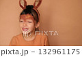 Funny playful girl dressed up as a horse jumps and runs laughing merrily, imitating an animal 132961175