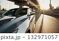 sleek gray sports car driving on an urban highway under an overpass during sunset, highlighting modern transportation and automotive design 132971057
