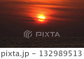 Dramatic sunrise with orange sky in a cloudy day at the ocean. 132989513