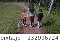 Mother walking with two children in forest 132996724