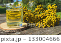 Tansy infusion in a glass Cup on a wooden table. Tansy is a medicinal plant used in folk medicine. 133004666
