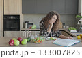 Woman Reading Book While Eating Fresh Salad In Modern Home Kitchen 133007825