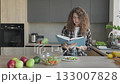 Female Reading Cookbook And Preparing Healthy Meal In Home Kitchen 133007828