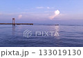 A Calm Sea View With Several Boats Passing By The Edge Of A Harbor Pier 133019130