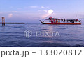 Ferry ship entering harbor at sunset with calm sea and colorful sky 133020812