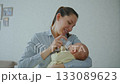 A young attractive brunette woman is feeding a baby formula to a breastfed baby. The concept of artificial quality feeding 133089623