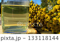 Tansy infusion in a glass Cup on a wooden table. Tansy is a medicinal plant used in folk medicine. 133118144