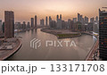 Cityscape of skyscrapers in Dubai Business Bay with water canal aerial day to night timelapse 133171708