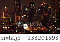Burry view of tall skyscrapers at night. Defocused windows and building top lights  133201593