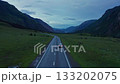 Aerial view of a car driving along a mountain road 133202075