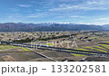 The Hokuriku Shinkansen train heading down runs with the Northern Alps in the background, followed by an ascending Shinkansen train a short distance later. 133202581