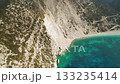 Aerial of winding coastal road and turquoise bay below cliffs at Myrtos Beach in Kefalonia Greece 133235414