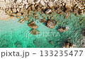 Aerial view of rocky shoreline and calm crystal clear sea water background 133235477