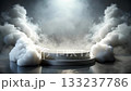A dark background and a stone podium shrouded in white and gray smoke 133237786