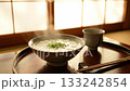 Steaming rice porridge with seven herbs on a warm dining table illuminated by the morning light in a Japanese-style room 133242854