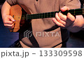 Man playing dombra in close-up indoors, detailed 4K view of strings and fingers with a pick 133309598