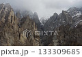 Aerial View of Snow-Capped Peaks in Pakistan's Northern Mountains, Capturing the Majestic Beauty of Cloud-Enveloped Rock Formations 133309685