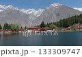 Scenic View of Traditional Buildings by a Lake in the Mountains of Pakistan, Featuring Snow-Capped Peaks and Pine Forests 133309747