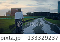 A high school student in uniform riding a bicycle along the seaside road in the evening 133329237