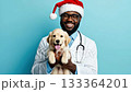 Smiling veterinarian in a festive Santa hat holds a playful puppy against a vibrant blue background, showcasing joy and connection in a heartwarming scene 133364201