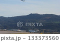Passenger Jet Taxis as Another Airplane Takes Off Over Mountains 133373560
