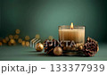 A glowing candle in a glass holder surrounded by pine cones and golden decor on a soft fabric, creating a warm festive atmosphere for winter celebration 133377939