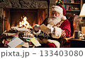 Santa Claus reads children's letters in a cozy armchair by a warm fireplace. Ideal for Christmas greeting cards, holiday ads, and festive storytelling concepts. 133403080