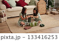 Children unwrap presents on Christmas morning. Winter holidays and New Year holidays 133416253