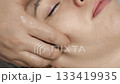 Facial massage treatment applying skincare cream close up in beauty clinic. 133419935