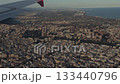 Airplane wing over coastal city during low approach 133440796