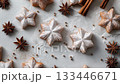 A minimalist flat lay of Christmas cookies coated with powdered sugar, cinnamon stick and star anise on parchment paper 133446671
