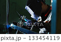 Precise welding process, operator performs detailed metal welding task 133454119