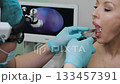 ENT doctor oral endoscopy exam with medical endoscope in clinic. 133457391