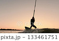 Thrilling Wakeboarding Adventure at Sunset: A Rider Gracefully Navigates the Water, Capturing the 133461751