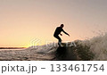 A Surfer Enjoys the Thrill of Riding Waves at Sunset, Capturing the Essence of Adventure and Freedom 133461754