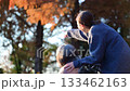 落ち葉散る秋の屋外で介護士と高齢者の顔なしのイメージ後ろ姿　高齢化社会や余生のイメージ 133462163