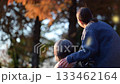 落ち葉散る秋の屋外で介護士と高齢者の顔なしのイメージ後ろ姿　高齢化社会や余生のイメージ 133462164