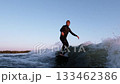 Dynamic Surfing Adventure: Captivating Moments of a Surfer Riding the Waves at Sunset with a 133462386