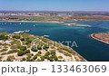 Aerial view drone shot of Tavira Portugal Algarve aerial view of ria formosa estuary with turquoise water, boats and marsh islands drone survey of wetlands, calm reflection, lush reeds, 133463069
