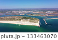 Aerial view drone shot of Tavira Portugal Algarve aerial view of channel entrance and coastal shoreline with boats navigating toward ria formosa local captain steering through clear green 133463070