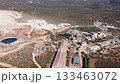 Aerial view site, Waterfilled quarry by industry, Surrounding landscape with processing facilities visible, Overview of mining area with water and infrastructure features 133463072