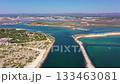 Aerial view drone shot of Tavira Portugal Algarve Aerial turquoise inlet near Tavira coastline with sandy spits, calm emerald water, small leisure boats, beach patches and protected 133463081